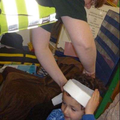 Elizabeth demonstrating how to wrap a head wound